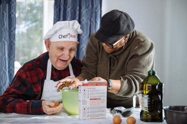Direct service professional attending to an individual in a cooking setting