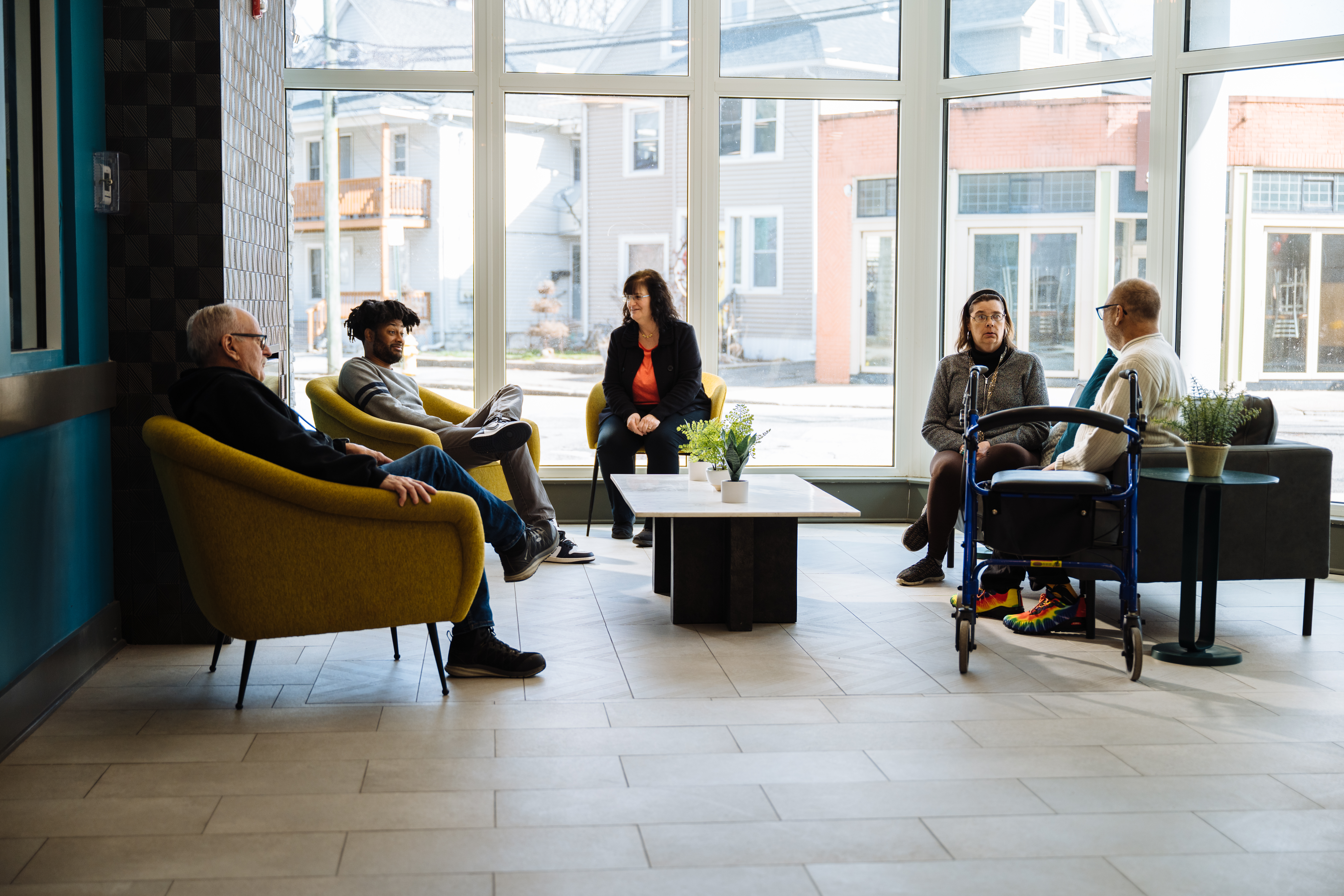 Individuals discussing supportive housing with family and support staff.