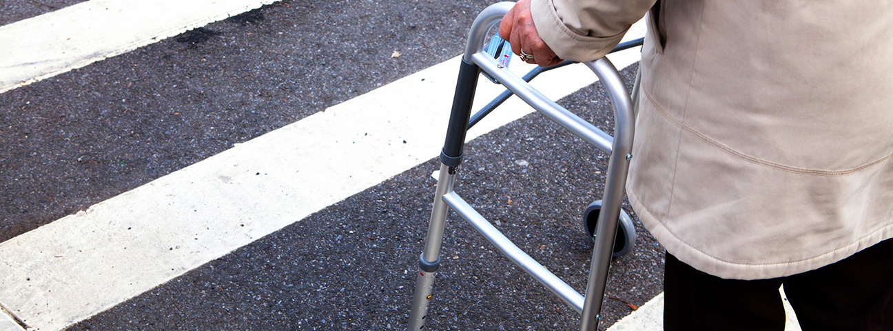 elderly with walking frame crossing street in a zebra crossing - mature pedestrian safety