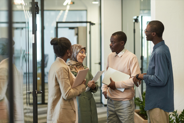 Employees speaking together in office lobby.