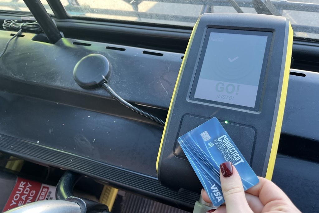 Hand holding a card to the contactless payment reader
