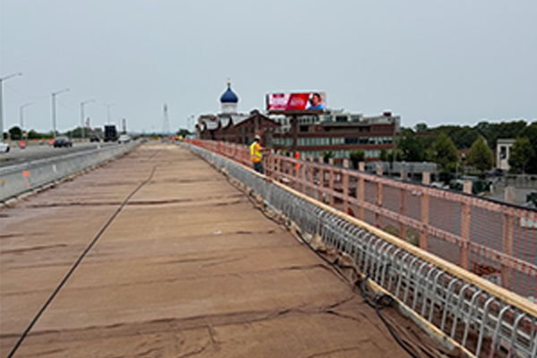 Wet concrete for the new bridge deck curing under a covering.
