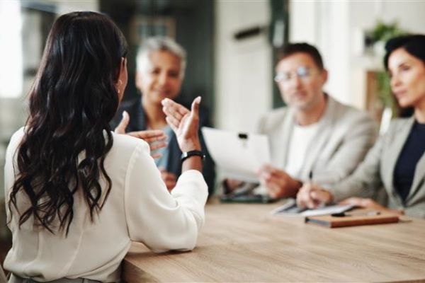Decorative image of a woman having a conversation with three coworkers