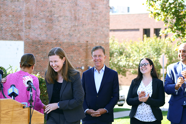 The Governor and staff members congratulating a person near a podium.