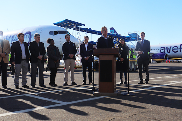 Governor Lamont making a speech with his staff behind him.