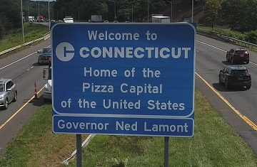 Interstate highway sign that says, "Welcome to Connecticut, Home of the Pizza Capital of the United States."