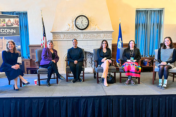 Women in Leadership panel with six speakers seated on stage.