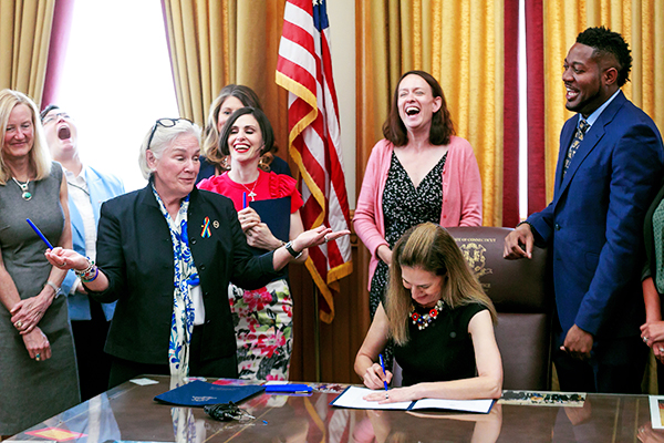 Lt. Governor Susan Bysiewicz signing a bill with a group of constituents.