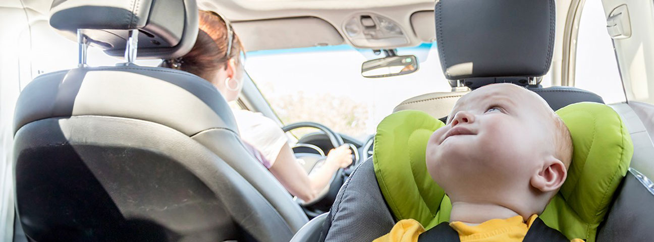 A baby in a rear facing car seat.