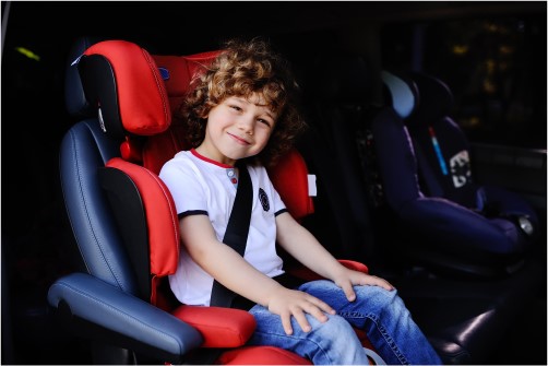 smiling boy in a child seat - don't forget about your child in their seat! - child passenger safety laws