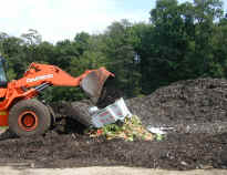 picture of a front loader at a farm moving food scraps