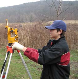 Student using land surveying equipment.