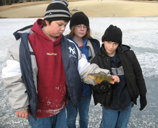 Boys learning how to ice fish.