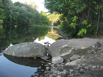 Construction of the current break boulders at the canoe/kayak launch site. Route 8 overpass in the background.