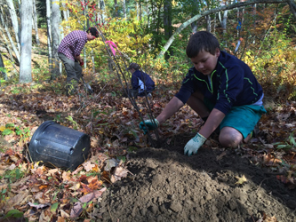 student volunteer planting native trees and shrubs