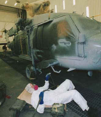 Sikorsky employee spraying paint on a helicopter