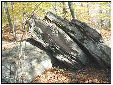 Loose schist and gneiss boulders lying on another boulder. 