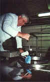 Picture of a Dairy Inspector drawing a milk sample from a bulk milk tank delivery truck.