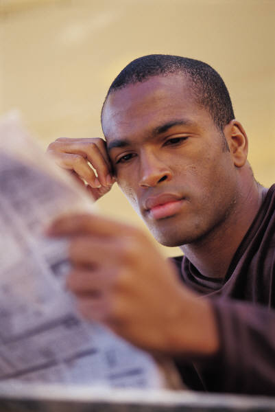 young man reading newspaper
