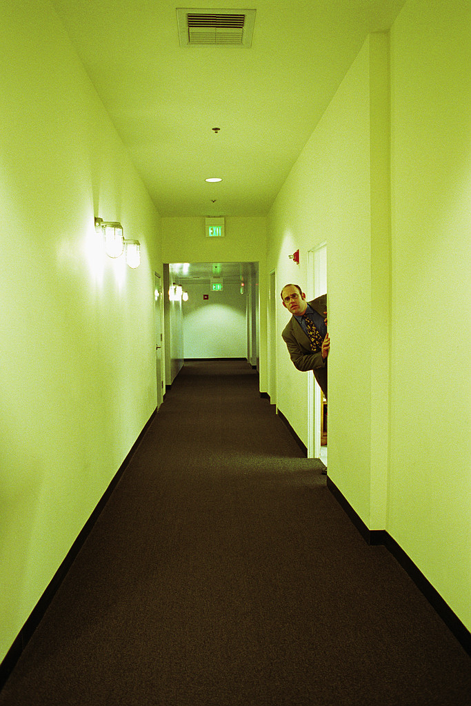 man looking out door in hallway