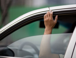 hand in car window with cigarette