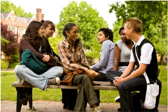 young adults sitting on campus bench