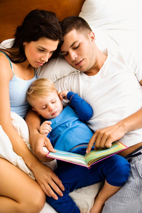 man,woman and baby reading a book