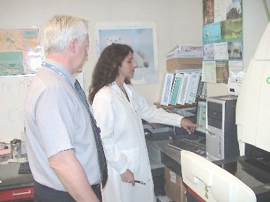 Photo of Bob Howard, Quality Assurance Director at the State Public Health Laboratory, discussing molecular subtyping of food-borne pathogens with a microbiologist.
