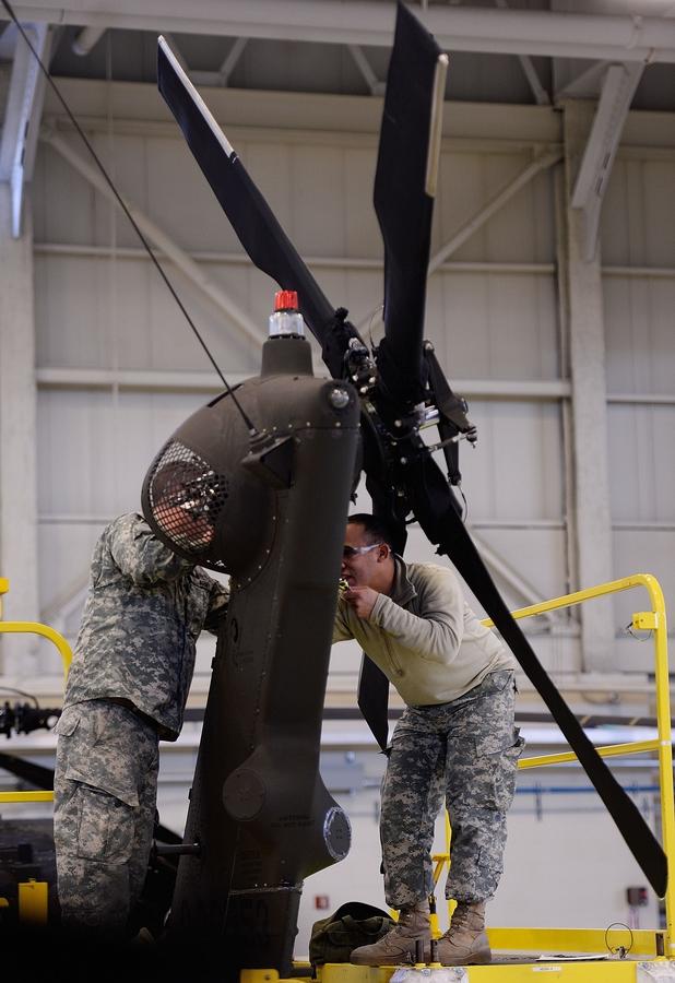 Corporal Geoff Flynn, left, and speicalist Jon Vega work on the tail of a Black Hawk helicopter.