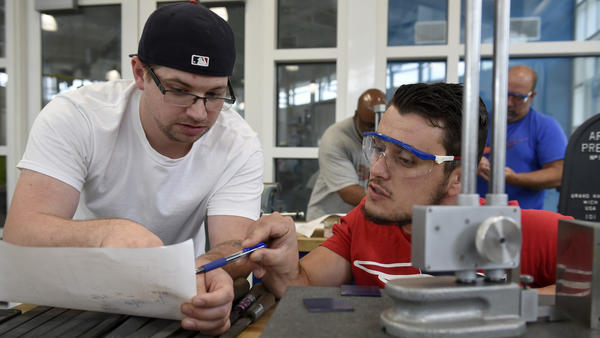 Students work together to figure out a measurement in a class at the Advanced Manf. Center at Quinebaug Valley Community Colleg