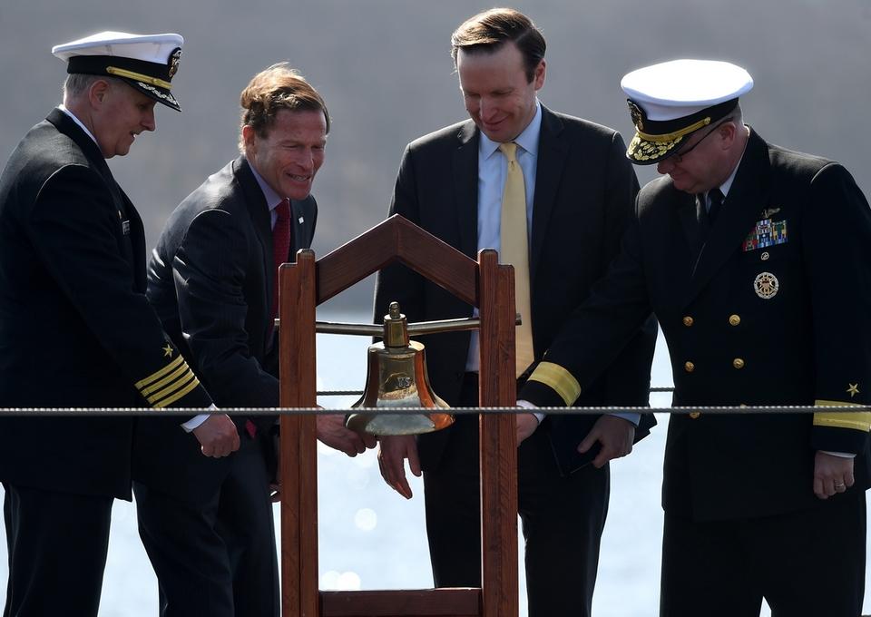 Sen Richard Blumenthal rings the bell while he and Capt. Whitescarver, Sen Chris Murphy and Rear Adm Pitts ring in the new year