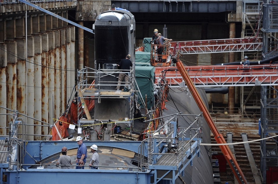 In this July 30, 2015 photo, shipyard workers at General Dynamics Electric Boat prepare the submarine Illinois.