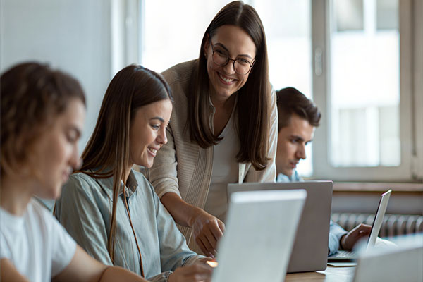 Woman teacher standing over two students