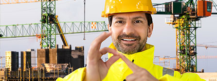A construction worker wearing a yellow security suit and helmet speaking in sign language