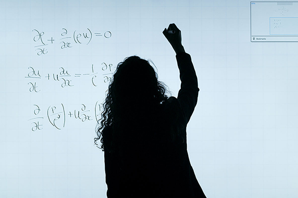silhouette of female teacher writing formula