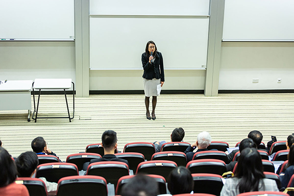 female teacher speaking to lecture crowd