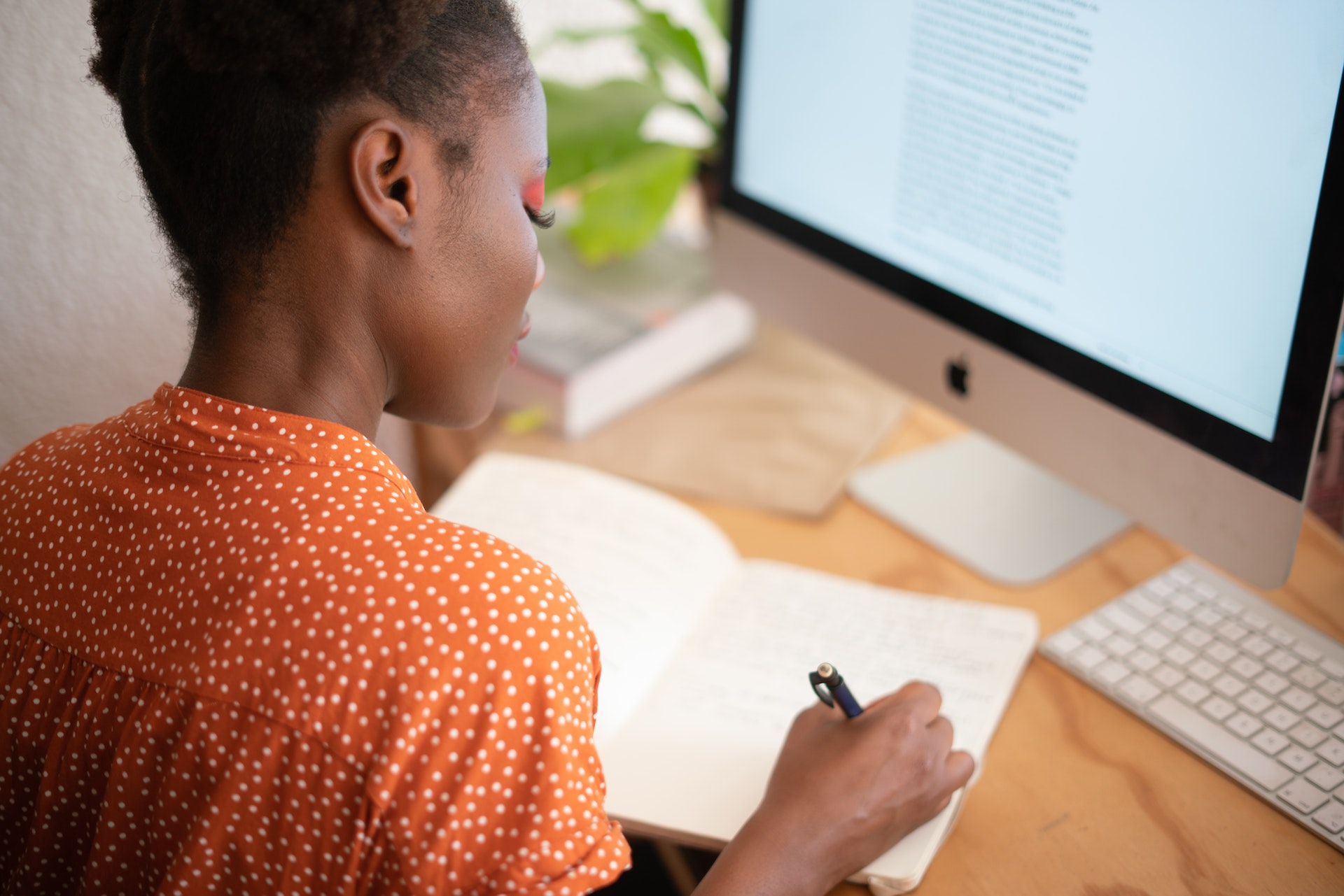 Woman reading computer and taking notes